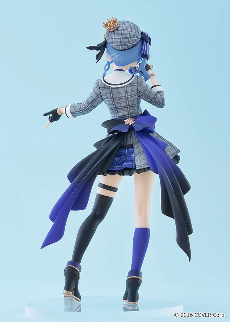 Figurine of a character in a plaid outfit with a blue ribbon against a light blue background
